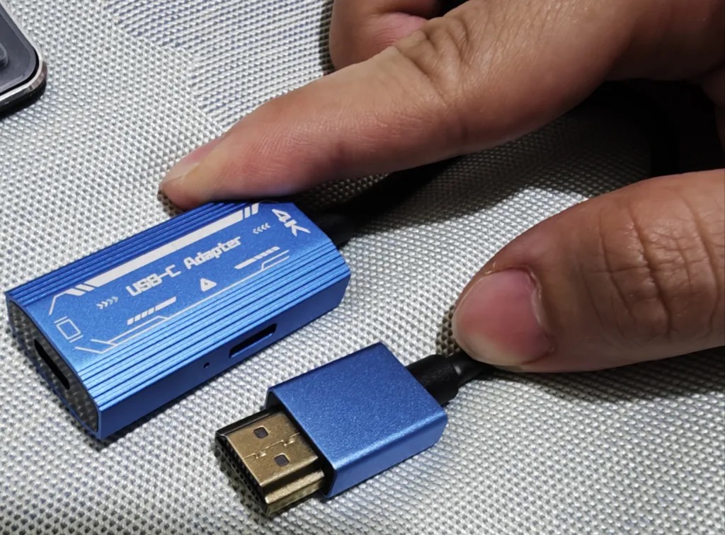 The same blue adapter with an HDMI cable about to be connected